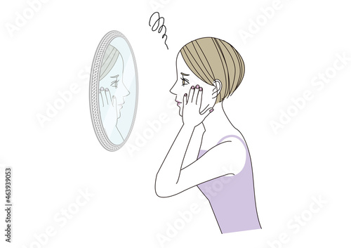 困った表情で鏡を覗き込んでいる女性