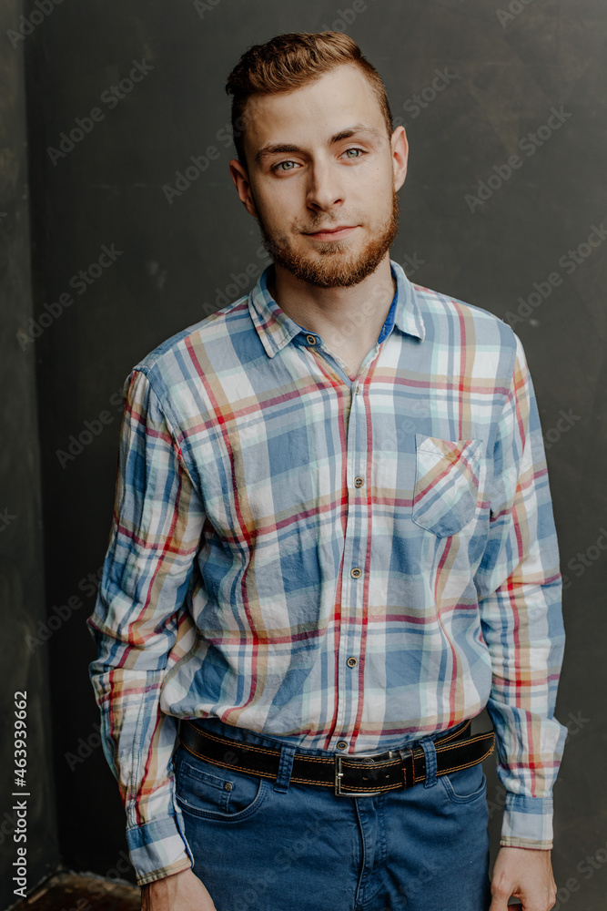 portrait of a young bearded man in shirt gray background