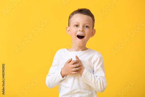 Portrait of surprised little boy on color background