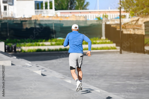 Sporty mature man running on stairs outdoors