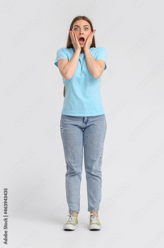 Shocked young woman in blue t-shirt on light background Shocked young woman in blue t-shirt on light background