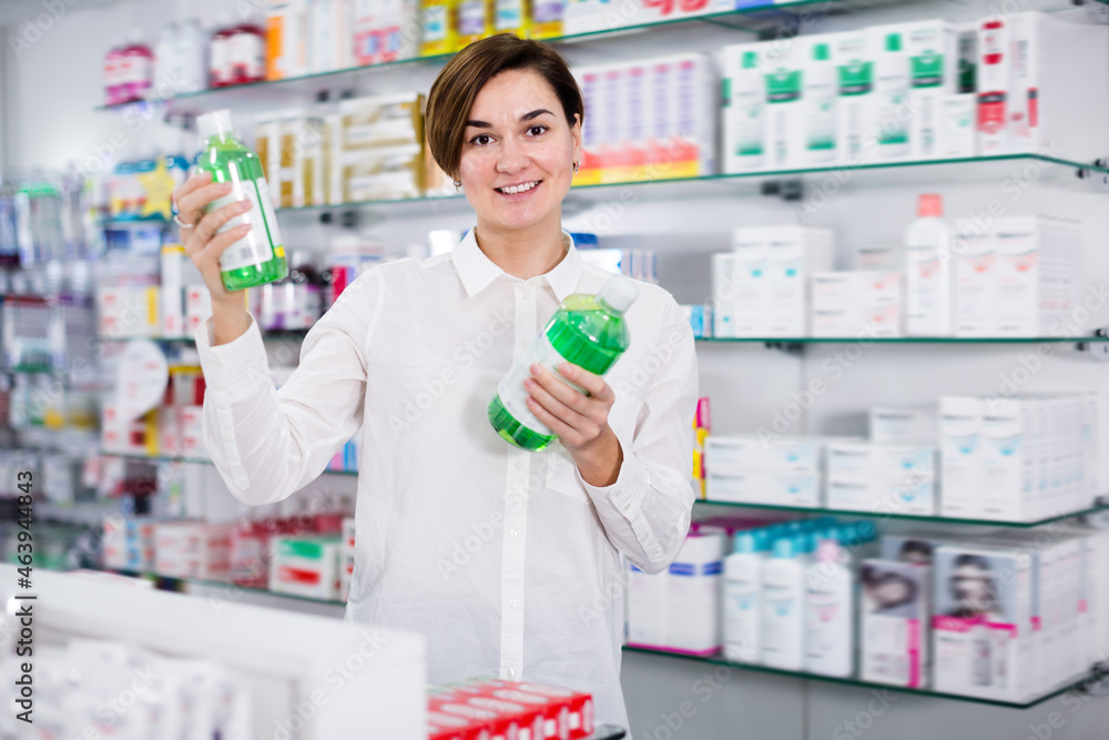 Female customer looking for products of body care in pharmacy