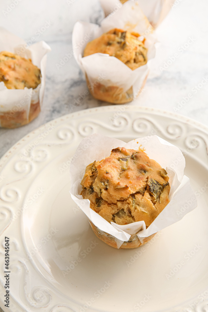 Plate with tasty spinach muffins on light background