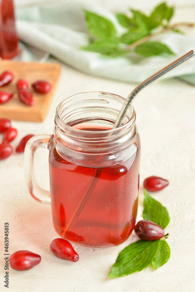 Mason jar of healthy dogwood berry drink on light background Mason jar of healthy dogwood berry drink on light background