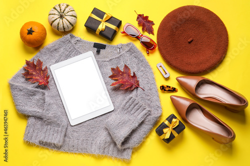 Stylish female accessories, tablet computer, gift boxes, dry leaves and pumpkins on color background. Black Friday sale