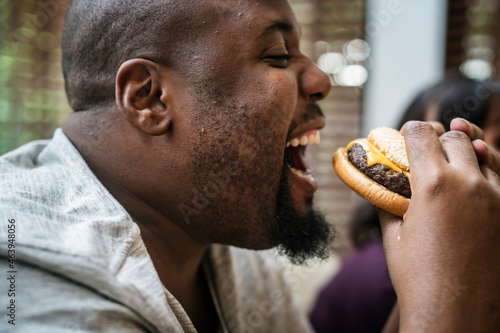 Man eating a big hamburger © Rawpixel.com
