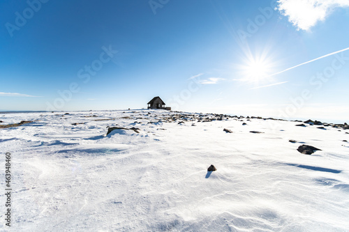 A  small building sits atop a snowy mountain. © MQphotos