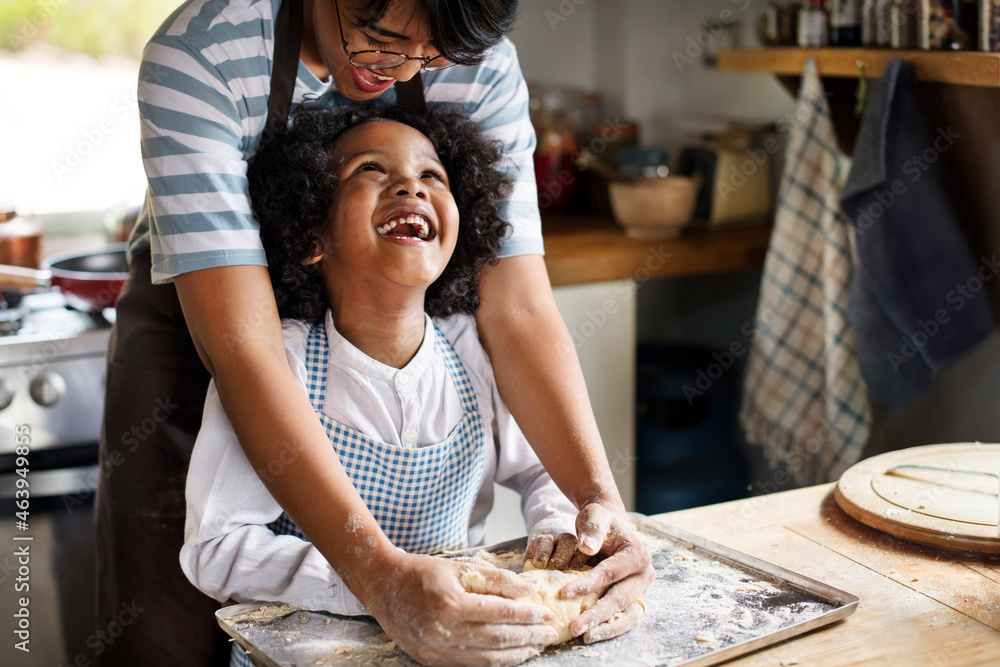 Young boy learning to bake with his mother - obrazy, fototapety, plakaty 