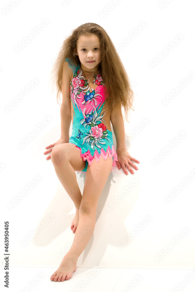 Charming little girl doing gymnastic exercises in the studio on a white background Charming little girl doing gymnastic exercises in the studio on a white background