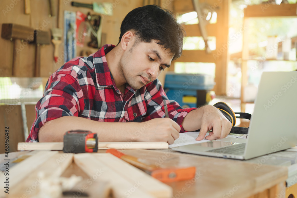 Owner entrepreneur startup small shop business. Professional of carpenter asian young man handcraft furniture making in hardwood, use laptop computer for marketing online. Factory Industry of wood. Owner entrepreneur startup small shop business. Professional of carpenter asian young man handcraft furniture making in hardwood, use laptop computer for marketing online. Factory Industry of wood.