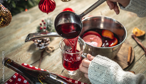 Cuadro en lienzo Woman is pouring fragrant hot mulled wine into a clear glass