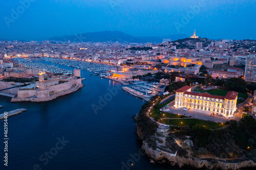 Bir's eye view of Marseille in evening with turned on city lights. Palais du Pharo visible from above.