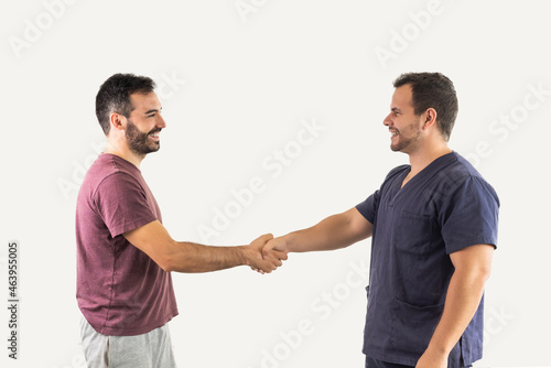 A grateful patient shakes hands with the physiotherapist after a rehabilitation session