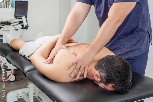 Physiotherapist massaging a patient's shoulder blade