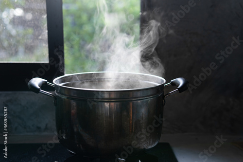 Steaming pot on black background. Smoke above boiling soup pot.,hot food and healthy meal concept