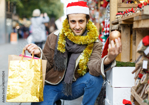 Young man expression happinnes from buying decoration at Christmas fair photo