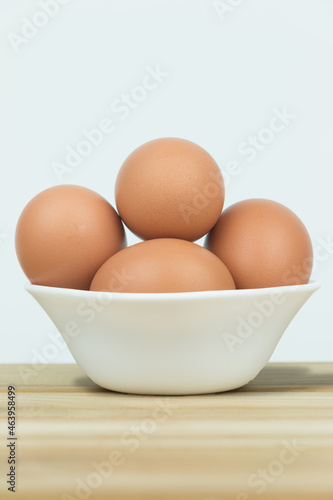Eggs in white cups lay on wooden floor.