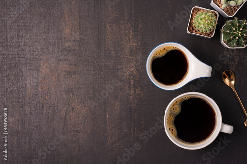 coffee cup with cactus on the wooden background with copy space, top view