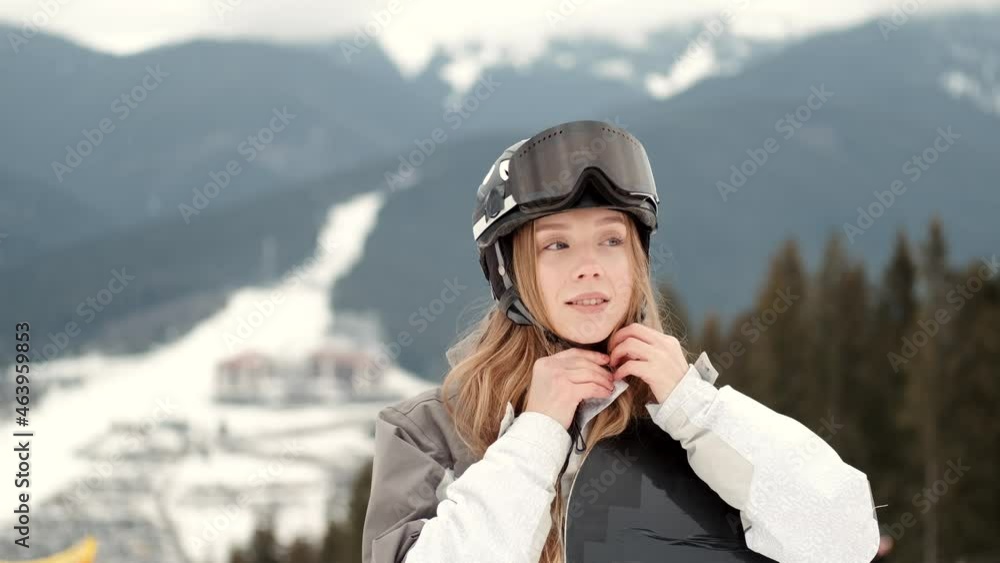 young girl snowboarder is smiling on the top of the mountain young girl snowboarder is smiling on the top of the mountain