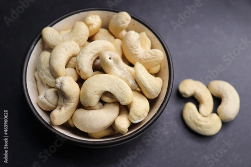 Tasty Cashew nuts in a mini wooden basket on the back background. Goan Kaju. Copy space. Dry fruits background or festivals banners. Diwali gift concept.