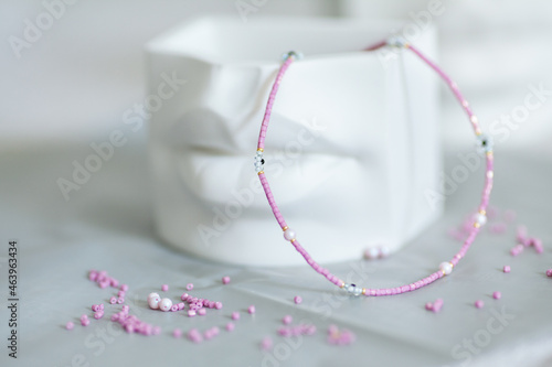 Pink delicate choker with daisies, stylish jewelry for women. White flower pot in the form of lips.