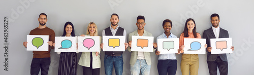 Different multiracial multiethnic people holding various cards and sheets of paper with pictures of colorful mockup chat message bubble icons. Concept of communication via messengers and social media
