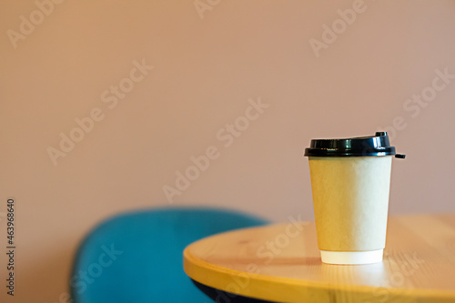 a paper cup with a lid in a cafe on the table