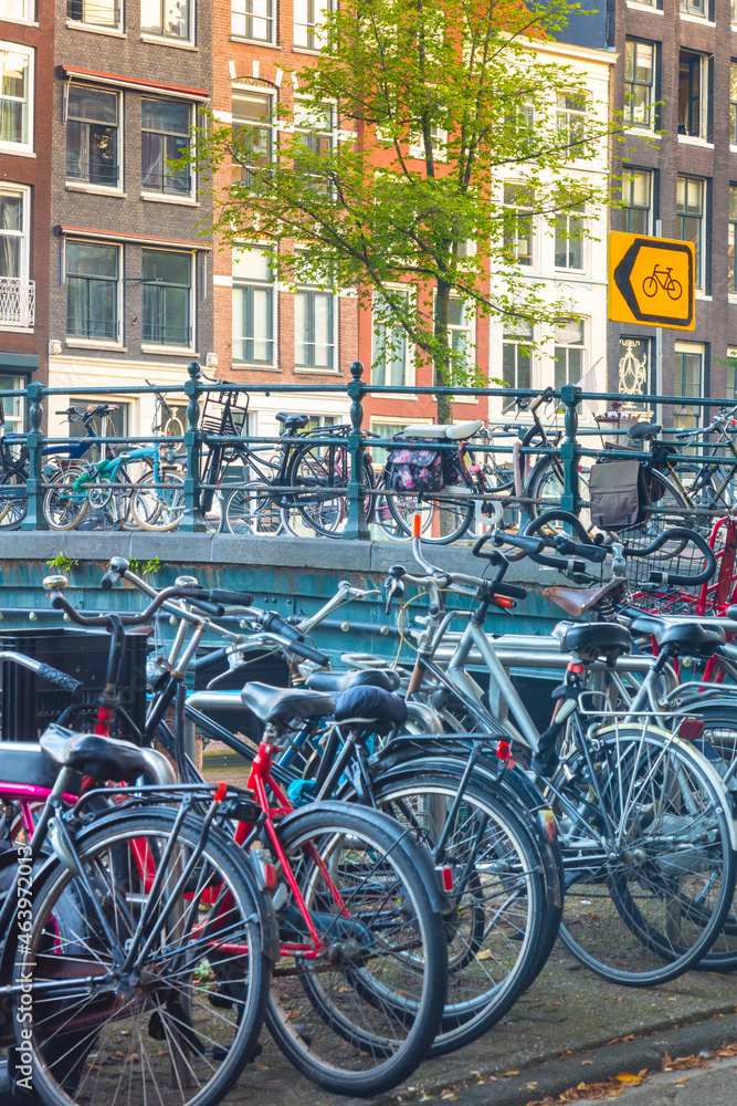 Popular bicycles in Europe..Ecological transport..Many bicycles are parked on the street and traditional old European houses. Amsterdam, Netherlands, Holland