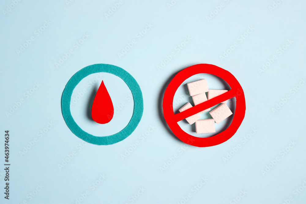 World diabetes day concept with symbol of diabetes and prohibition sign on sugar lumps on blue background. World diabetes day concept with symbol of diabetes and prohibition sign on sugar lumps on blue background.