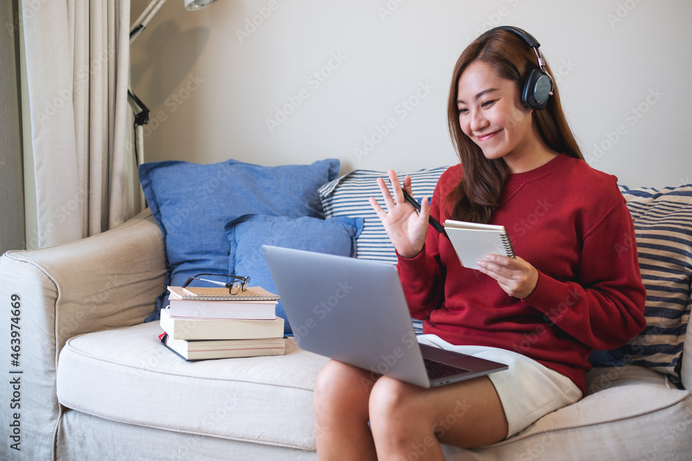 A young woman with headphone using laptop computer for online study at home A young woman with headphone using laptop computer for online study at home