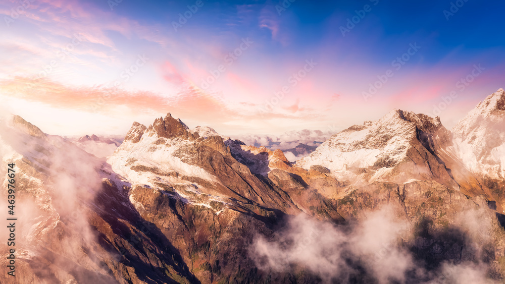 Aerial View of Canadian Rocky Mountains with snow on top. Colorful Sunset Sky Art Render. Nature Landscape located near Chilliwack, East of Vancouver, British Columbia, Canada.