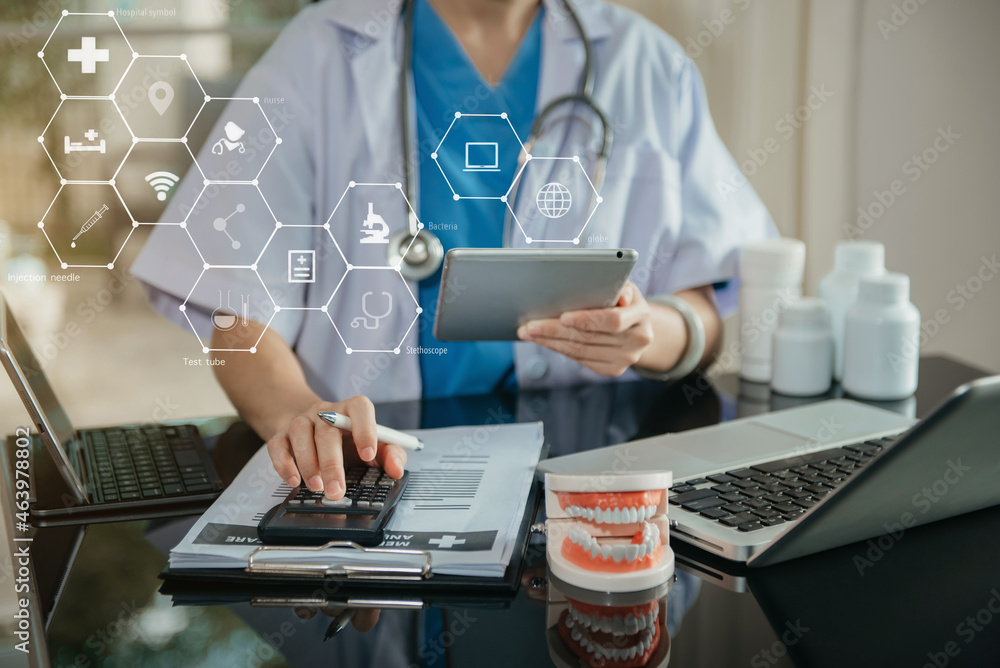 Doctor physician with stethoscope calculate medical fee costs & revenue. practitioner use calculator at clinic. Doctor physician with stethoscope calculate medical fee costs & revenue. practitioner use calculator at clinic.