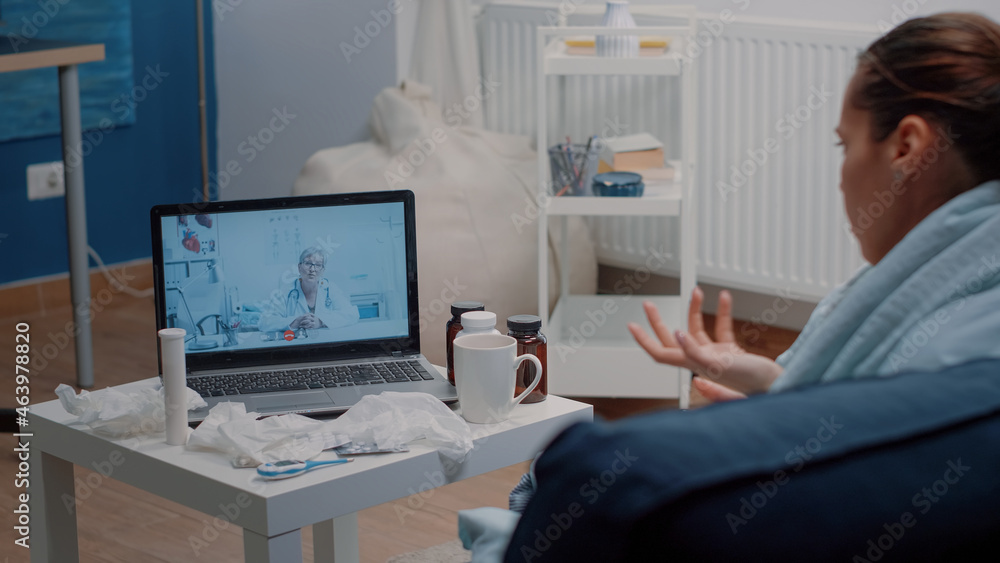 Patient with headache using video call for telemedicine and telehealth, asking doctor about treatment to cure pain and flu symptoms. Woman talking to specialist on online remote conference Patient with headache using video call for telemedicine and telehealth, asking doctor about treatment to cure pain and flu symptoms. Woman talking to specialist on online remote conference