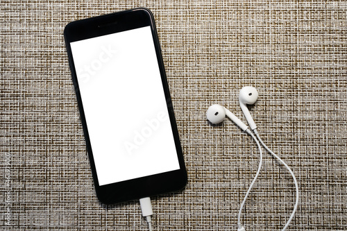 mobile phone with headphones on gray brown background, screen mockup