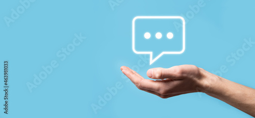 Businessman holding a message icon, bubble talk notification sign in his hands. Chat icon, sms icon, comments icon, speech bubbles