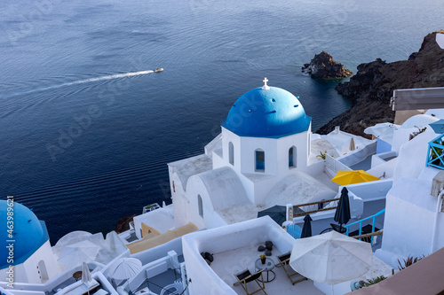 View from viewpoint of Oia village with blue domes of greek orthodox Christian churches and traditional whitewashed greek architecture. Santorini, Greece