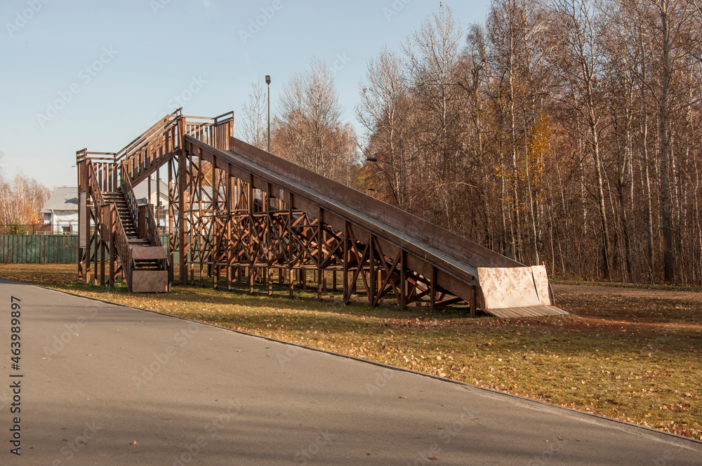 large wooden slide for sleds. Empty inactive in the autumn