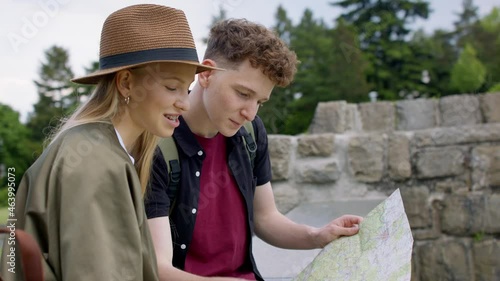 Young couple travelers with map in city on holiday, sightseeing. photo