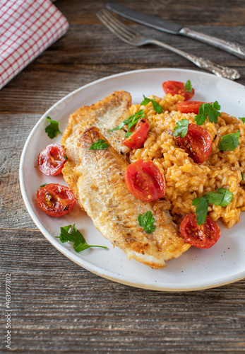 Fried fish fillet served with risotto roasted cherry tomatoes