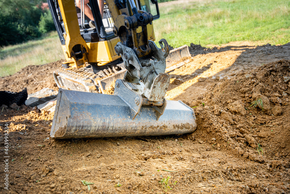 Fototapeta premium Mini Excavator bucket closeup during work on construction site