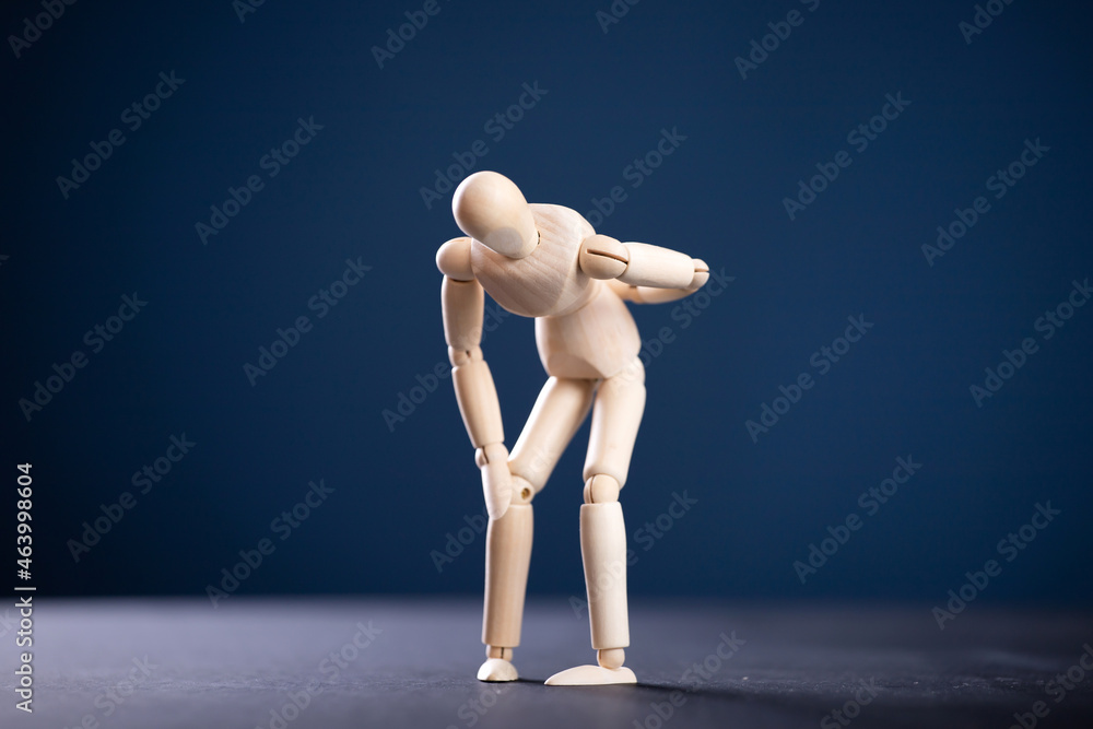 Concept of back pain. A wooden figure depicts a pain in the back. Concept of back pain. A wooden figure depicts a pain in the back.
