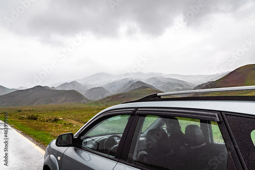 Car on wet asphalt road in mountainous area
