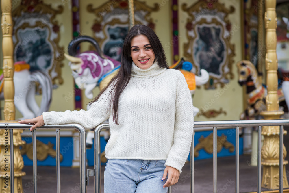 Happy and attractive caucasian brunette girl posing in an amusement park.