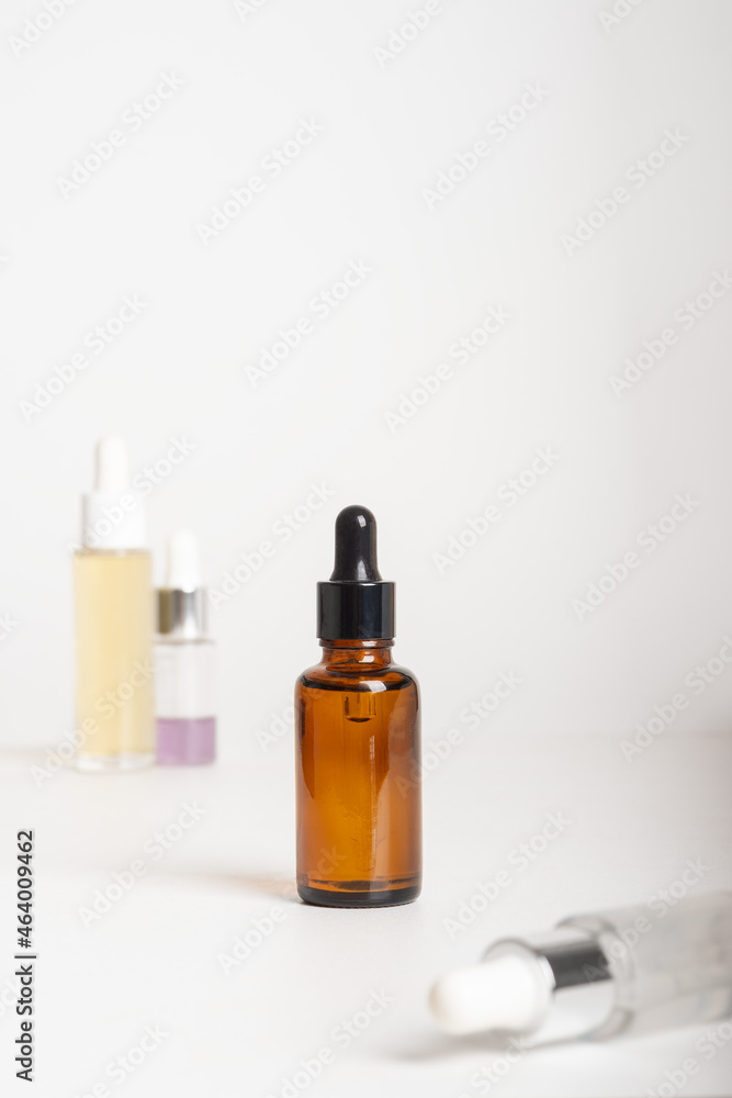 Fototapeta premium Spa cosmetics in different dropper bottles on grey background. Copy space for text. Beauty blogger, salon therapy, branding mockup, minimalism concept. Various Facial Massage Oils For Spa Treatment.
