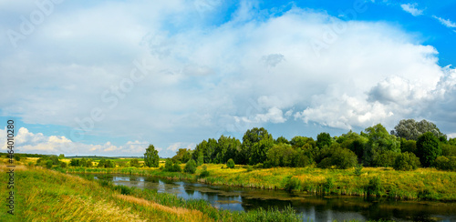 Bright summer landscape with lake and green trees