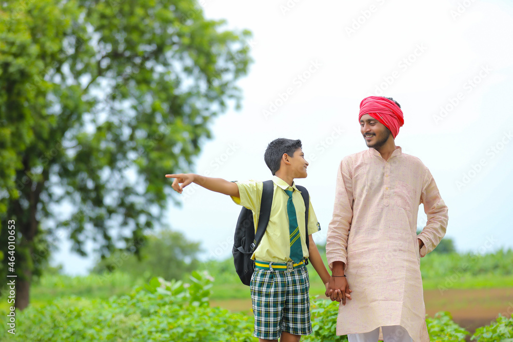 Indian farmer with his son at agriculture field.