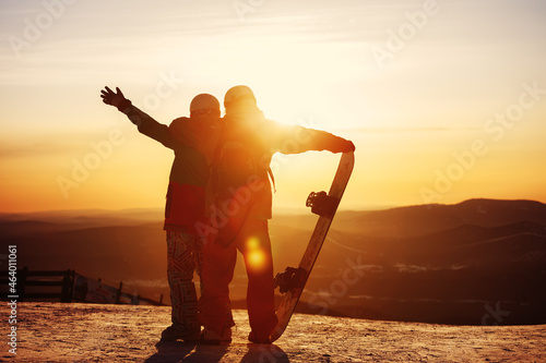 Loving couple of young people with a snowboard in deep snow. photo