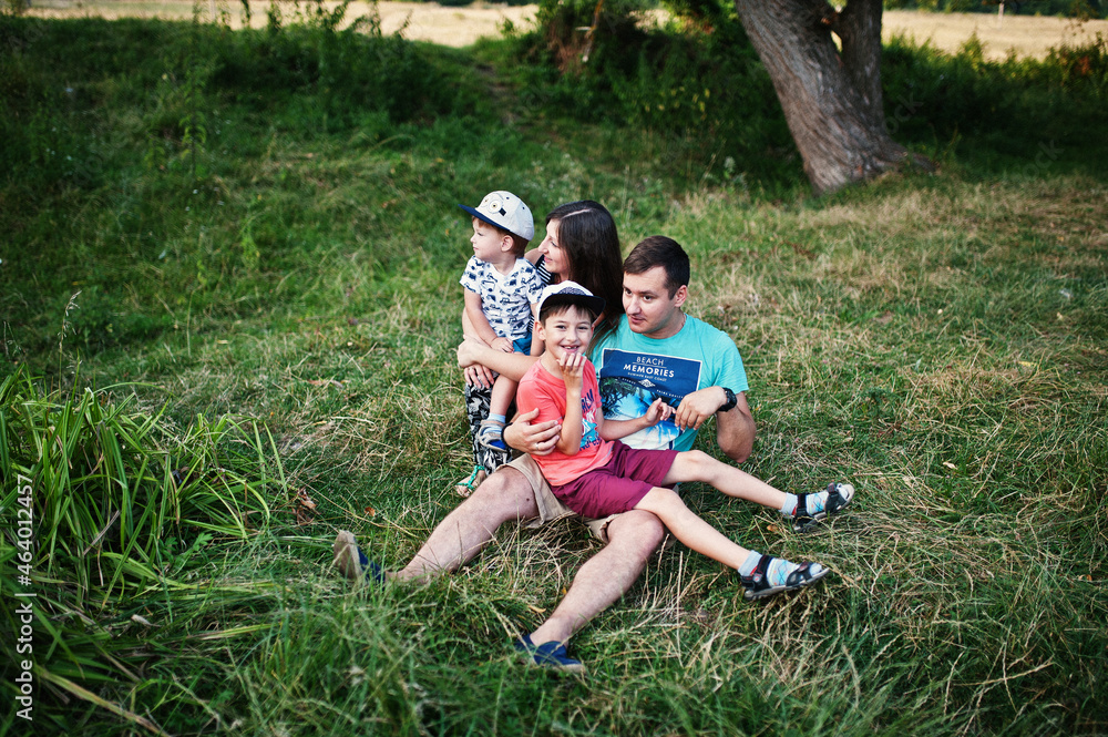 Fototapeta premium Happy young family: mother, father, two children son on nature having fun.