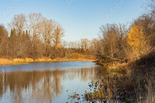 Beautiful landscape of a calm river against the backdrop of an autumn forest.
