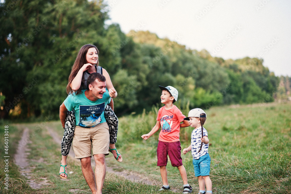 Happy young family: mother, father, two children son on nature having fun.